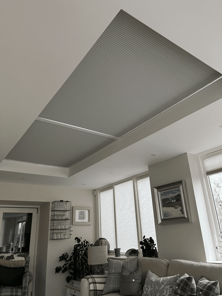 Closed grey thermal roof blinds and matching window blinds in a cosy Cupar living room.